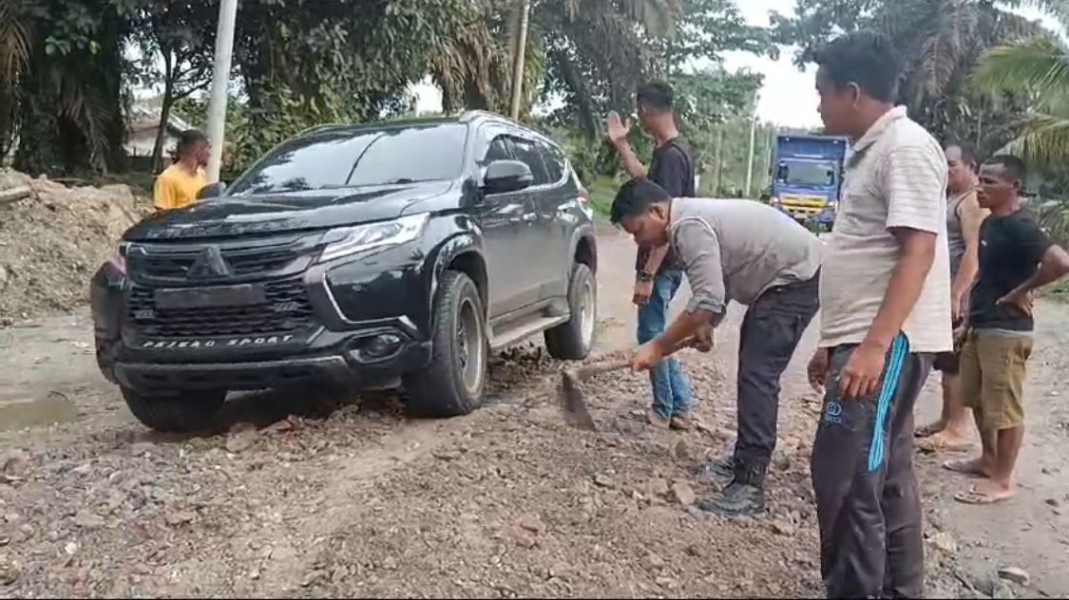 Polsek Singingi Hilir Bersama Warga Gotong Royong Perbaiki Jalan Lintas Sumatera