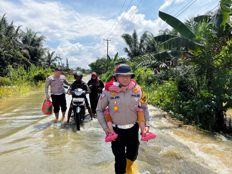 Arus Banjir Desa Sei Raya Makin Deras, Kasat Lantas Polres Inhu Evakuasi Pengguna Jalan