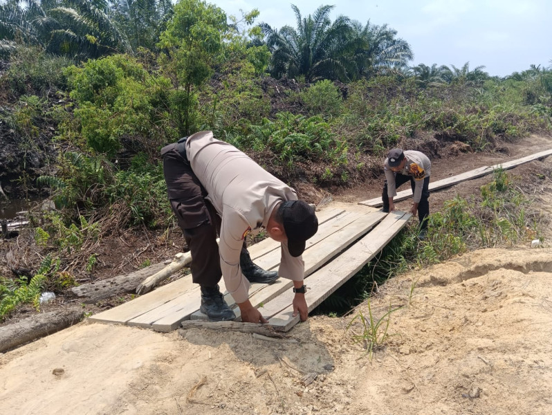 Bhabinkamtibmas Desa Merbau dan Desa Kriung Bantu Warga Bangun Jembatan Demi Pilkada Damai 2024